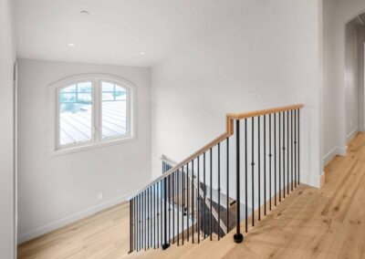 Custom modern staircase with white oak handrail and black iron balusters