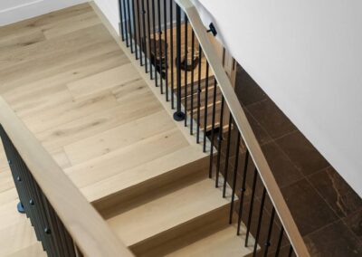 Custom wood staircase with iron railing in modern home interior.